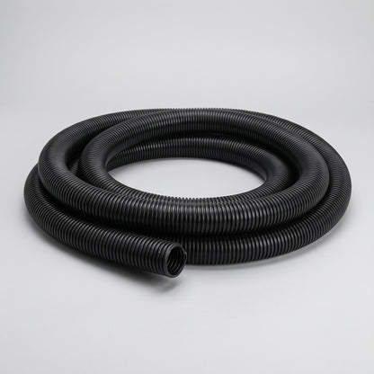 Coil of black spiral corrugated flexible pond hose on a plain grey background