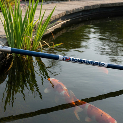 Pond skimmer net beside a clear UK garden koi pond – PondLiners Co