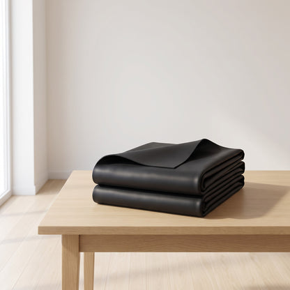 Folded black EPDM rubber pond liner on a wooden table with one corner turned back