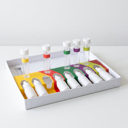 Liquid pond water test kit tray with colour-coded sections, white dropper bottles and capped test tubes on a white table