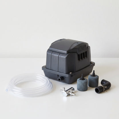 Pond air pump kit with clear airline, two cylindrical air stones, two-way air valve and elbow connector on a plain neutral background