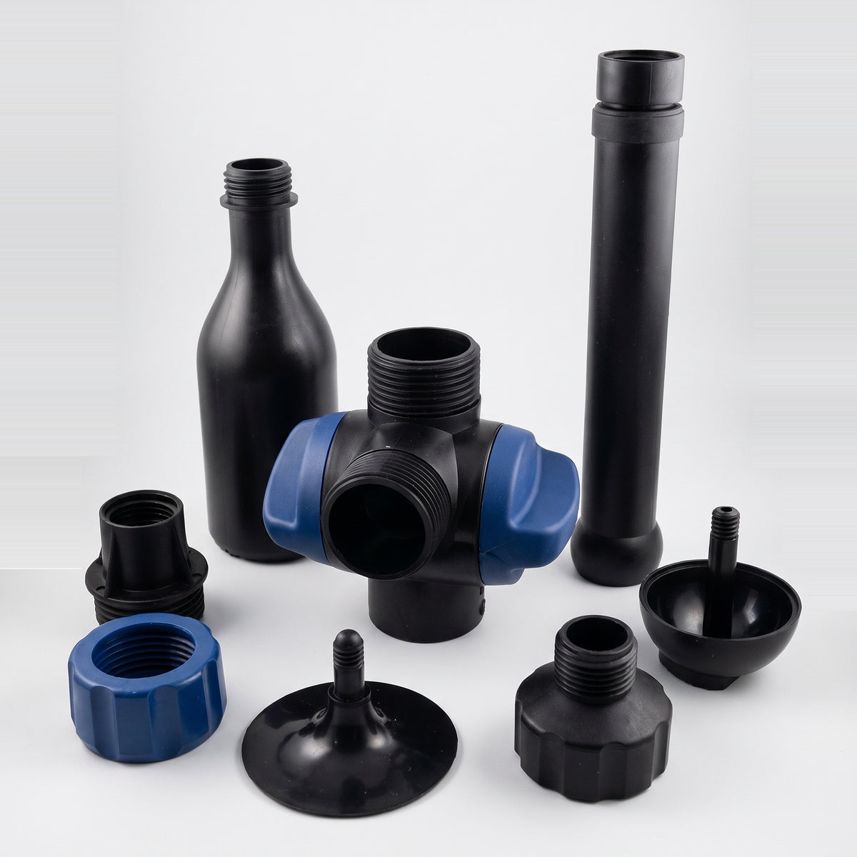 Pond fountain nozzle kit parts on a white background: foaming jet nozzle, telescopic riser, T-piece with two blue flow valves, hose tail, nut, adapter, domed and flat disc heads