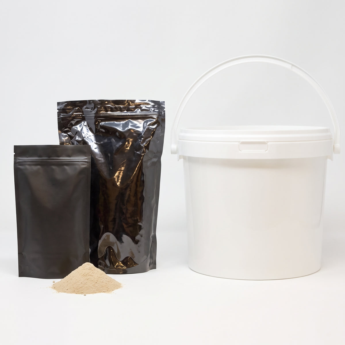 Cold water pond bacteria powder in two black pouches and a white 5kg tub with a heap of beige powder on a white background